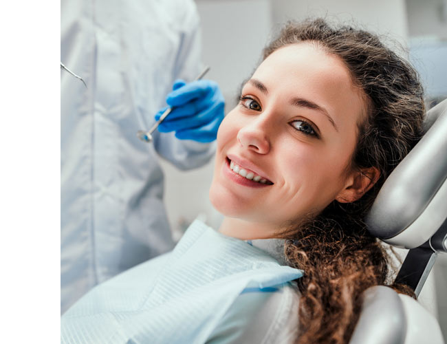 smiling woman in a dentist's chair during treatment